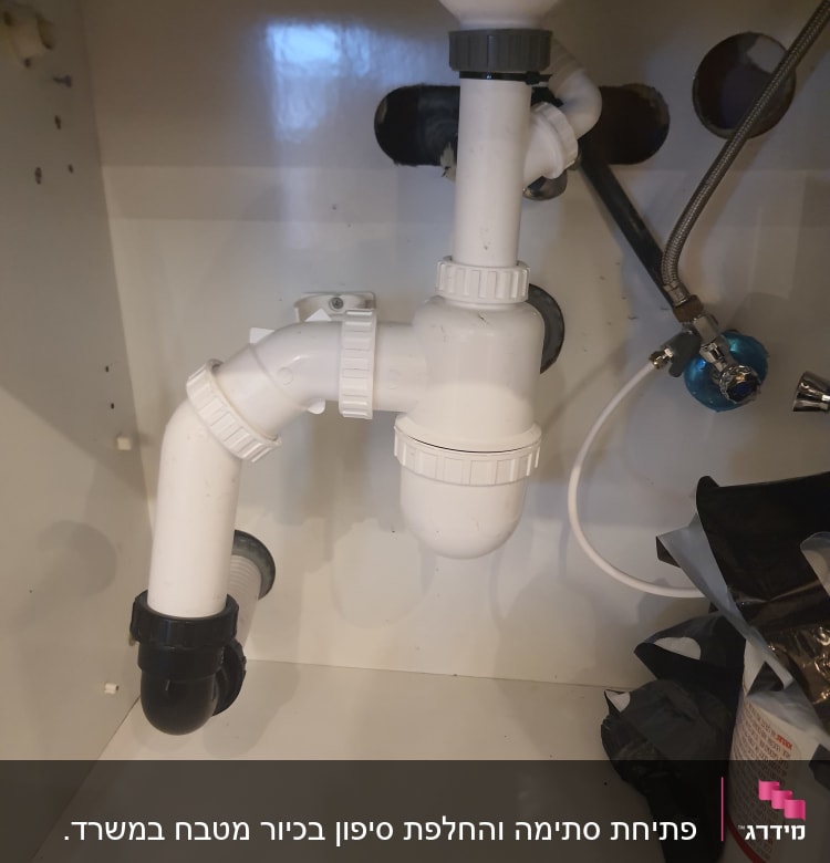 צנרת פלסטיק לבנה מתחת לכיור עם מחברים
